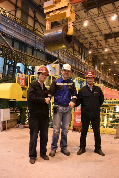 Shaking hands in front of the first coil produced on the fourth Arvedi ESP line at Rizhao Steel: Yu Yao, Plant Manager ESP lines, Rizhao Steel; Harald Monn-Weiss, Site Manager Primetals Technologies; Xie Jibiao, Overall Plant Manager ESP Melt shop, Rizhao Steel (from left to right).